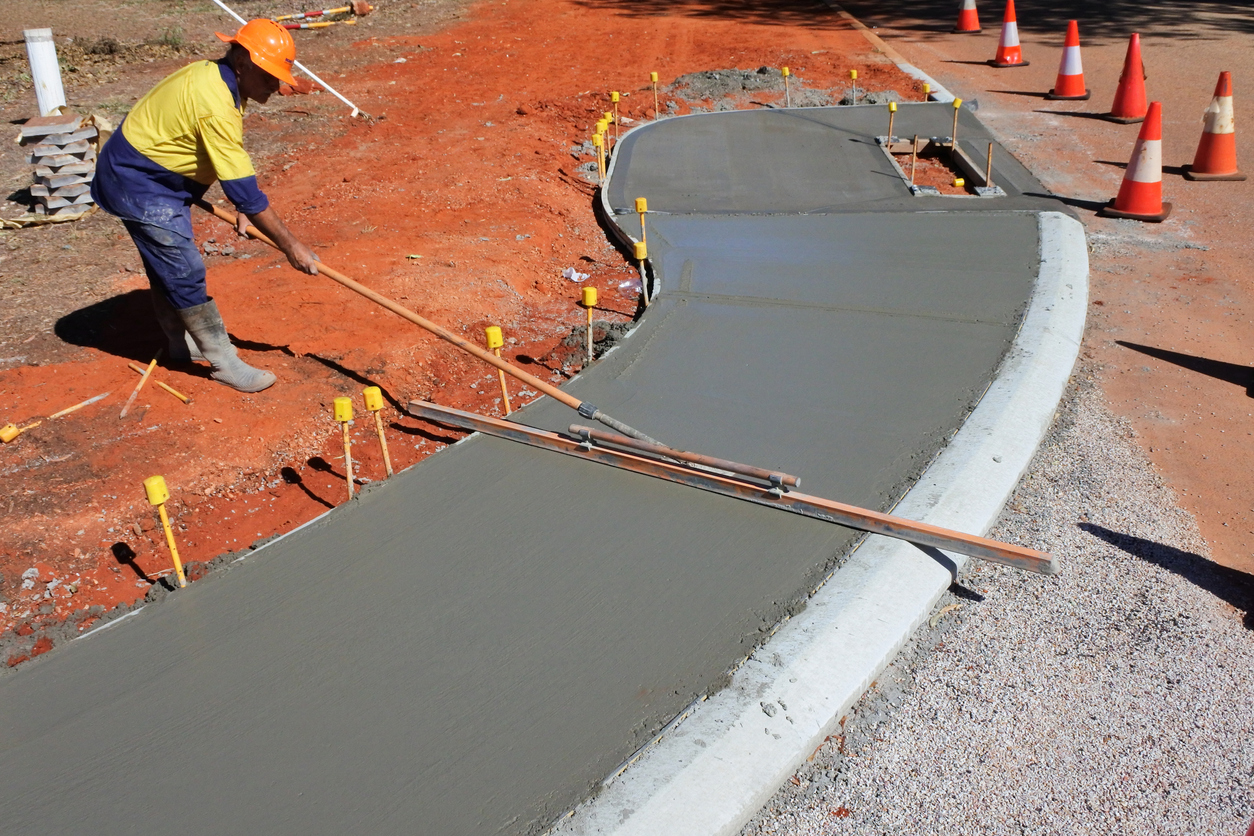 Broome, Wa - July 05 2022:Australian road worker leveling a concrete sidewalk.Australia's roads sector contributing $236 billion to the nation's economy each year and support 1.4 million workers.